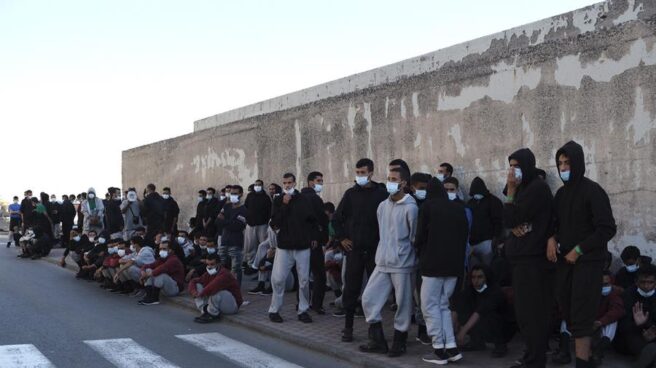 Un grupo de inmigrantes tras ser desalojado del muelle de Arguineguín.