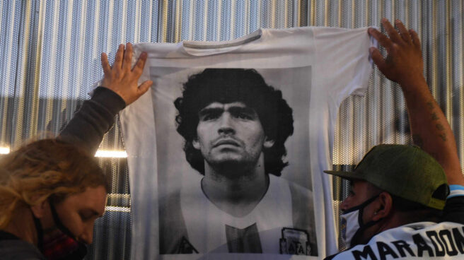 Hinchas cuelgan camisetas conmemorativas de Maradona en el hospital donde fue operado a principios de noviembre.