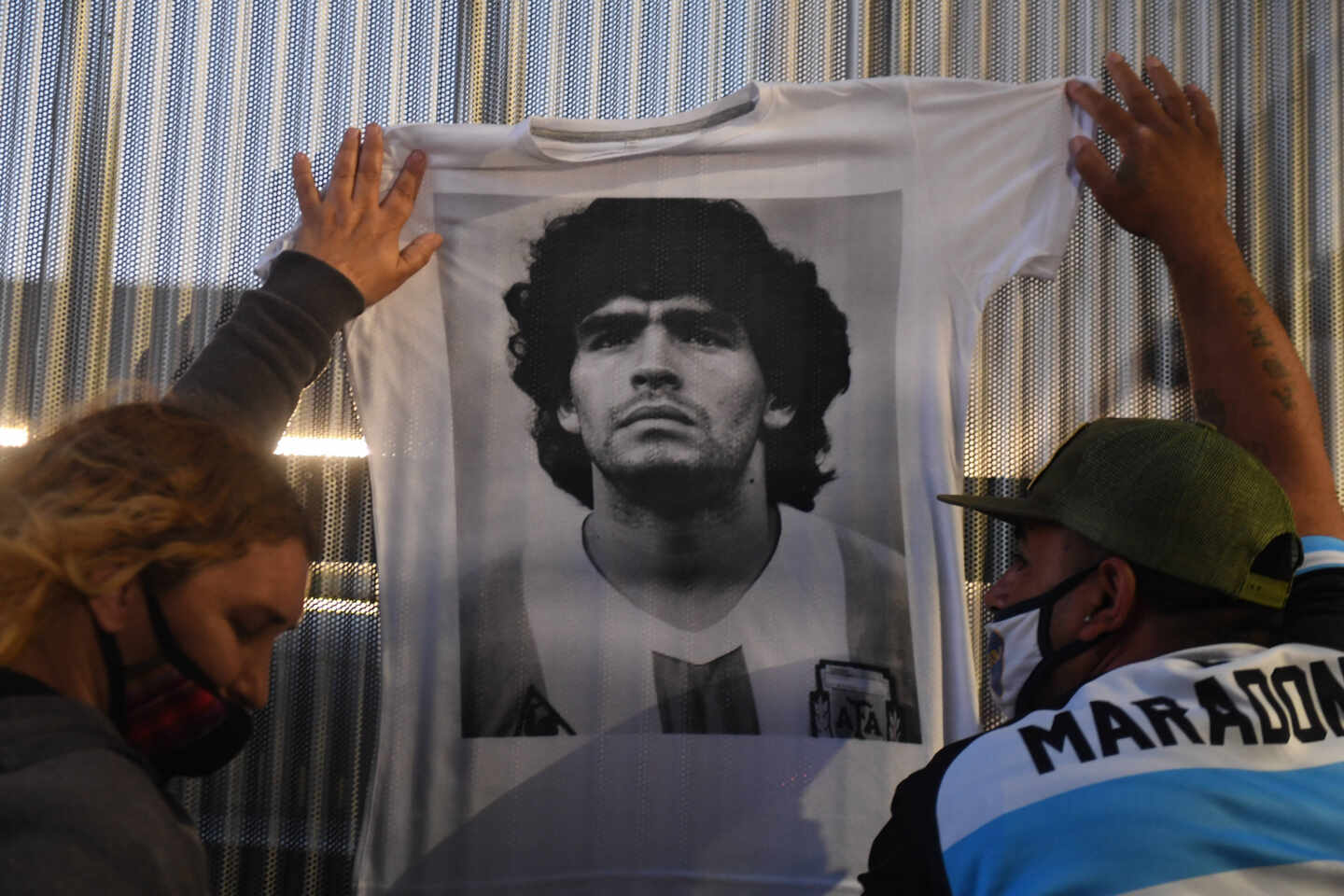 Hinchas cuelgan camisetas conmemorativas de Maradona en el hospital donde fue operado a principios de noviembre.