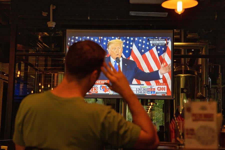 Un hombre ve por televisión al presidente Donald Trump durante la noche electoral.