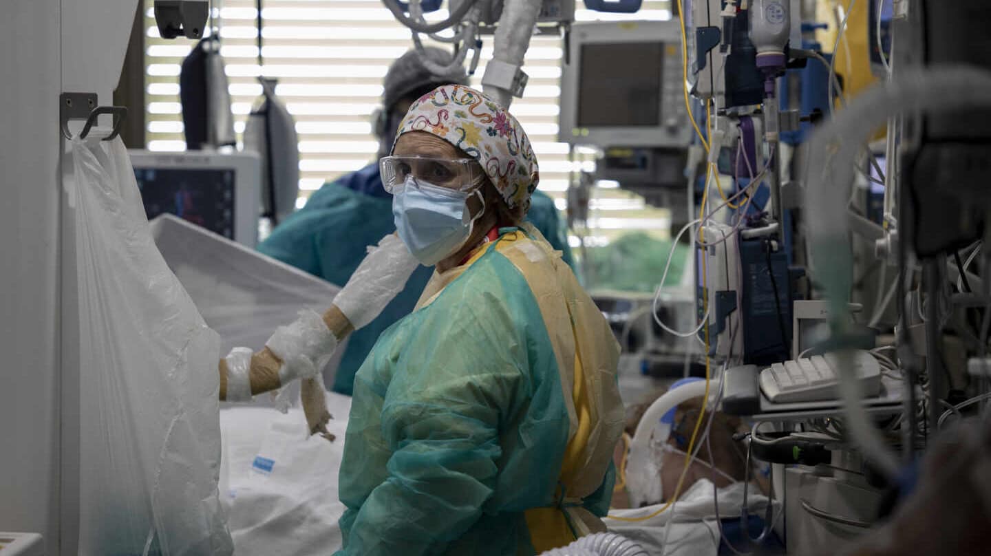 Dos sanitarios atienden a un paciente en la Unidad de Cuidados Intensivos (UCI) del Hospital Universitario Ramón y Cajal, en Madrid (España).