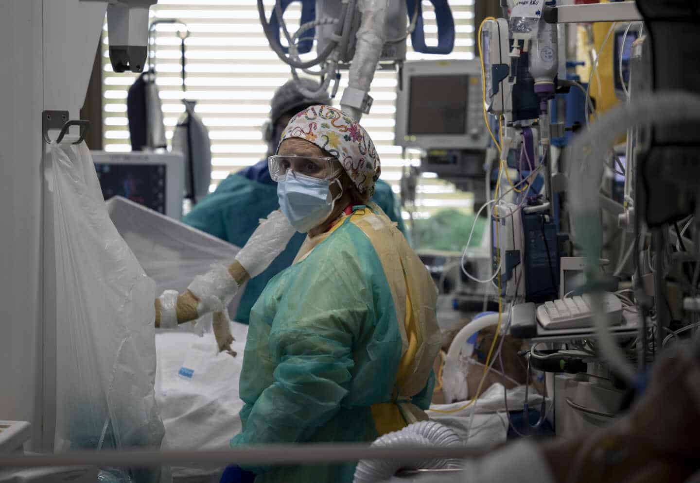 Dos sanitarios atienden a un paciente en la Unidad de Cuidados Intensivos (UCI) del Hospital Universitario Ramón y Cajal, en Madrid (España).