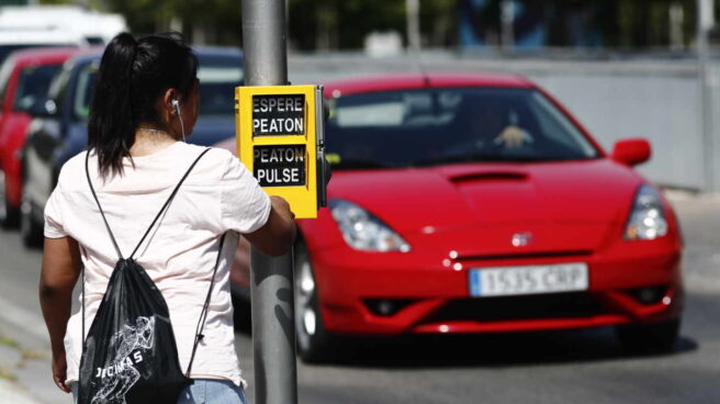 Una chica se dispone a cruzar la calle, en Madrid.