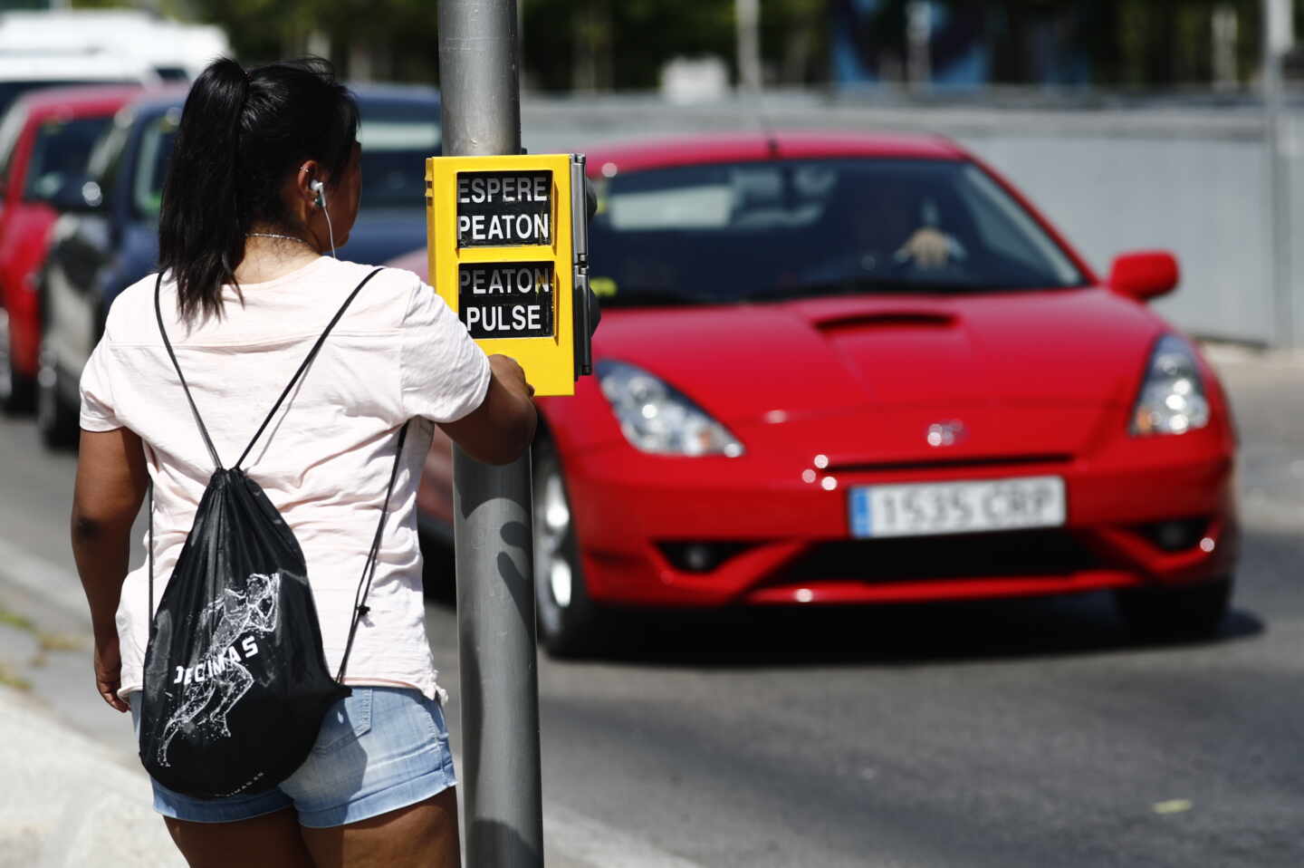 Una chica se dispone a cruzar la calle, en Madrid.