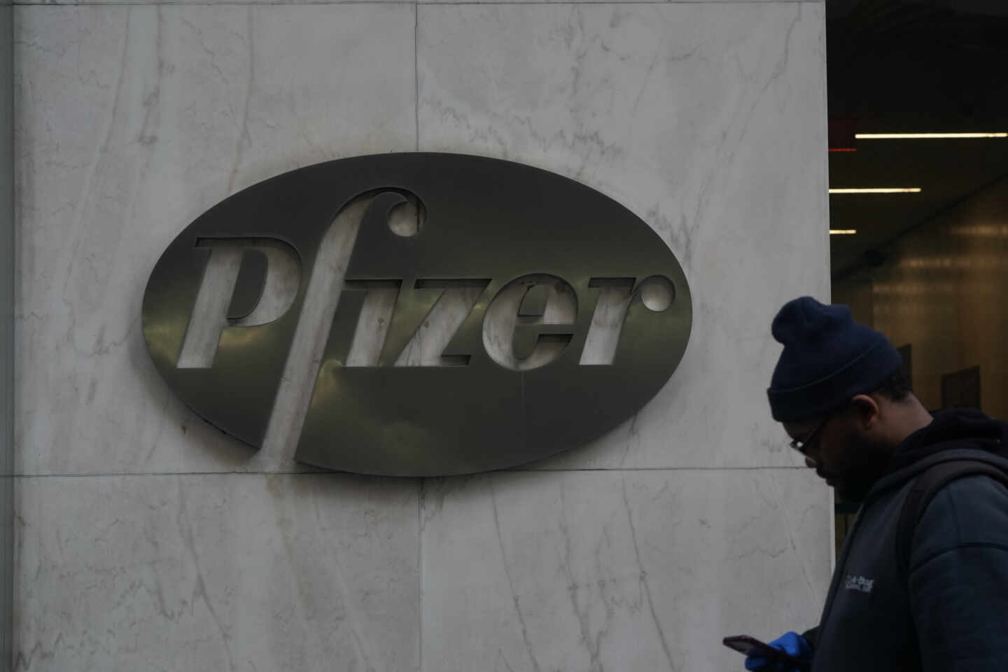 Un hombre camina ante la sede de la farmacéutica Pfizer en Nueva York.