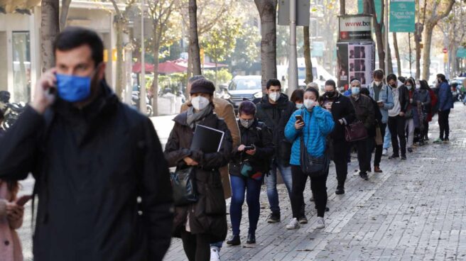 Multitud de personas hacen cola para hacerse test de antígenos en un laboratorio privado de Barcelona.