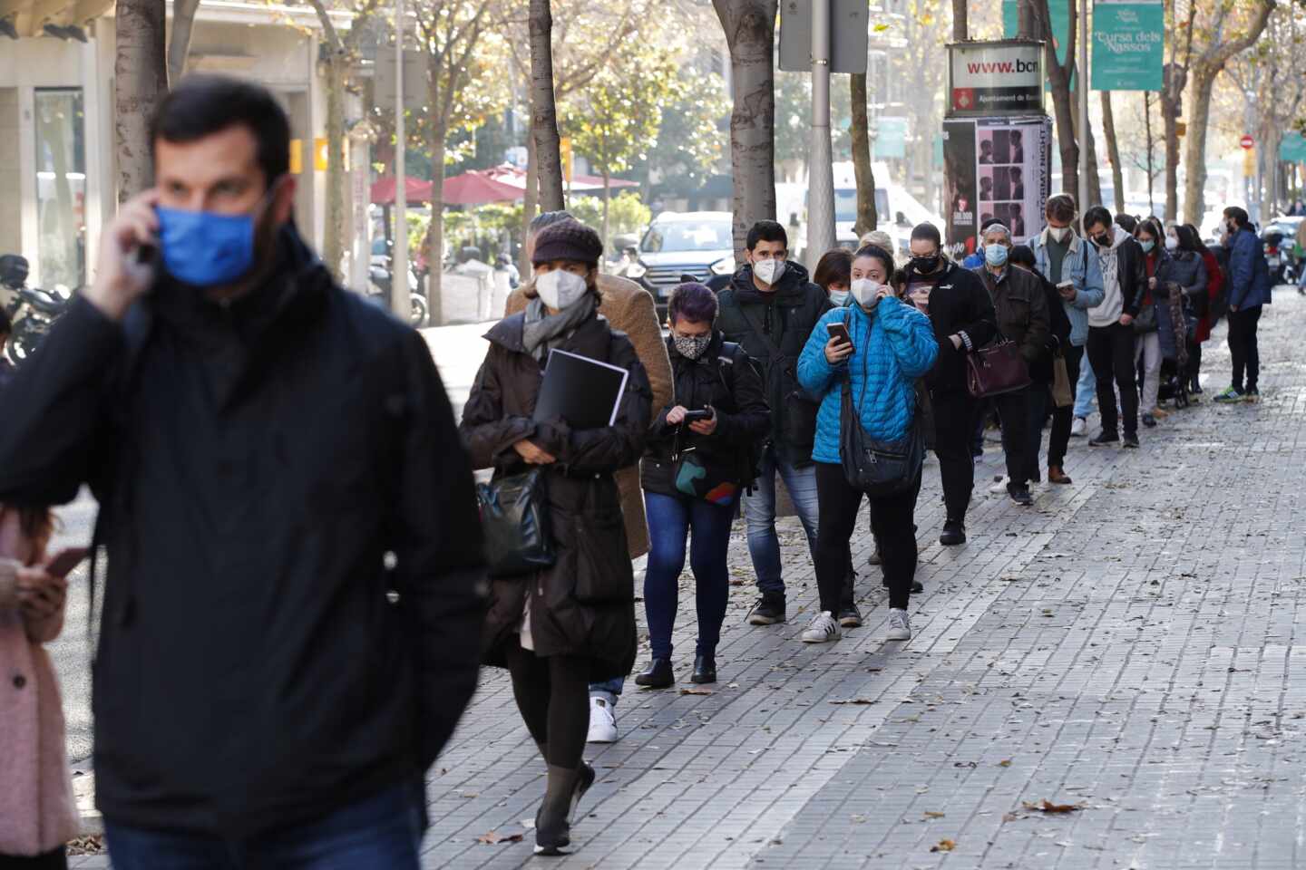 Multitud de personas hacen cola para hacerse test de antígenos en un laboratorio privado de Barcelona.