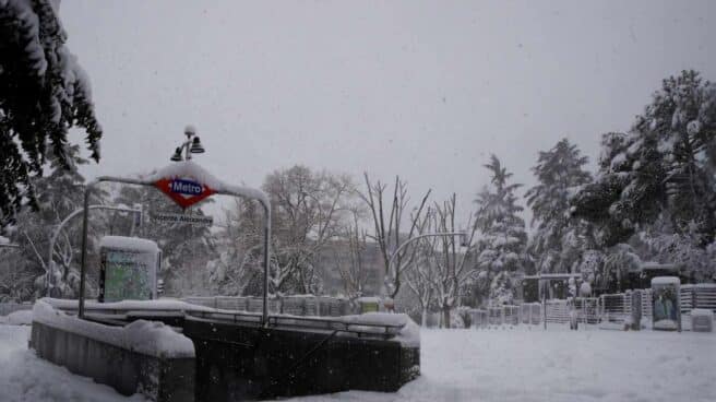 Entrada a la estación de metro Vicente Aleixandre cubierta de nieve en Madrid.