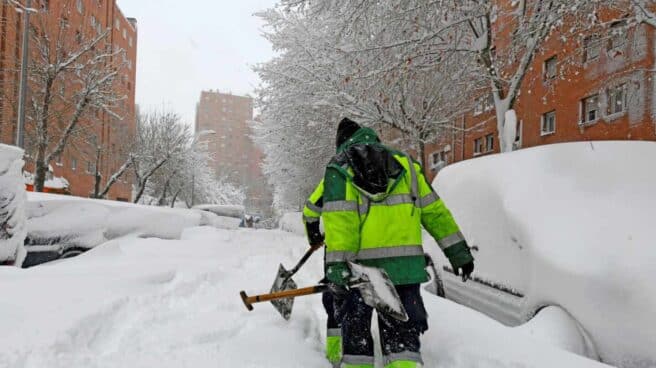 Operarios de los jardines de las viviendas de Sierra Toledana en Vallecas tratan de hacer camino para los vecinos.