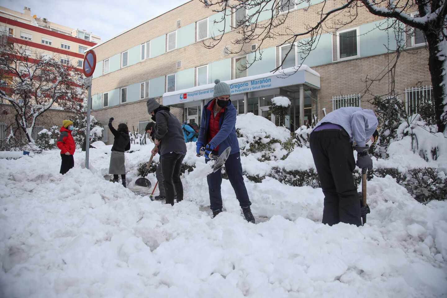 Voluntarios limpian la entrada del hospital Gregorio Marañón de Madrid.