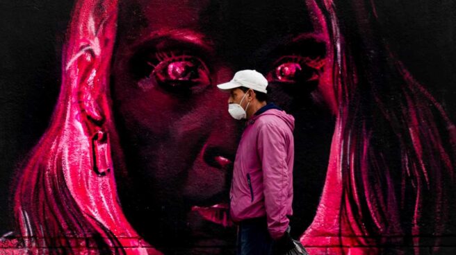 Una persona pasa frente a un grafitti este lunes en Barcelona