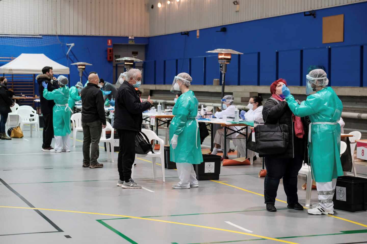 Varias personas se someten a una prueba de antígenos durante el cribado masivo para detectar casos covid-19 en un polideportivo.