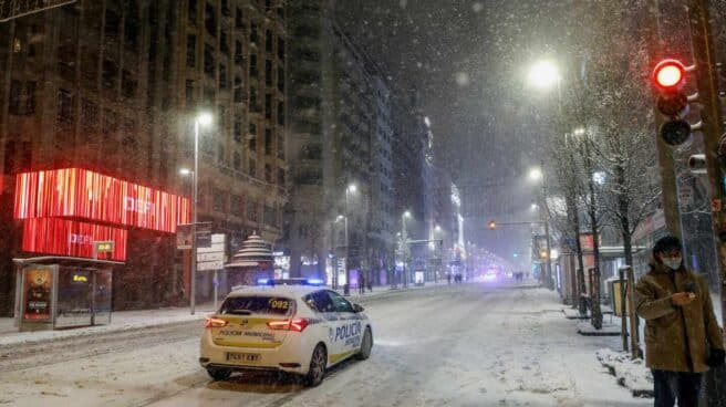 Un coche de la policía municipal transita por la Gran Vía, en Madrid.