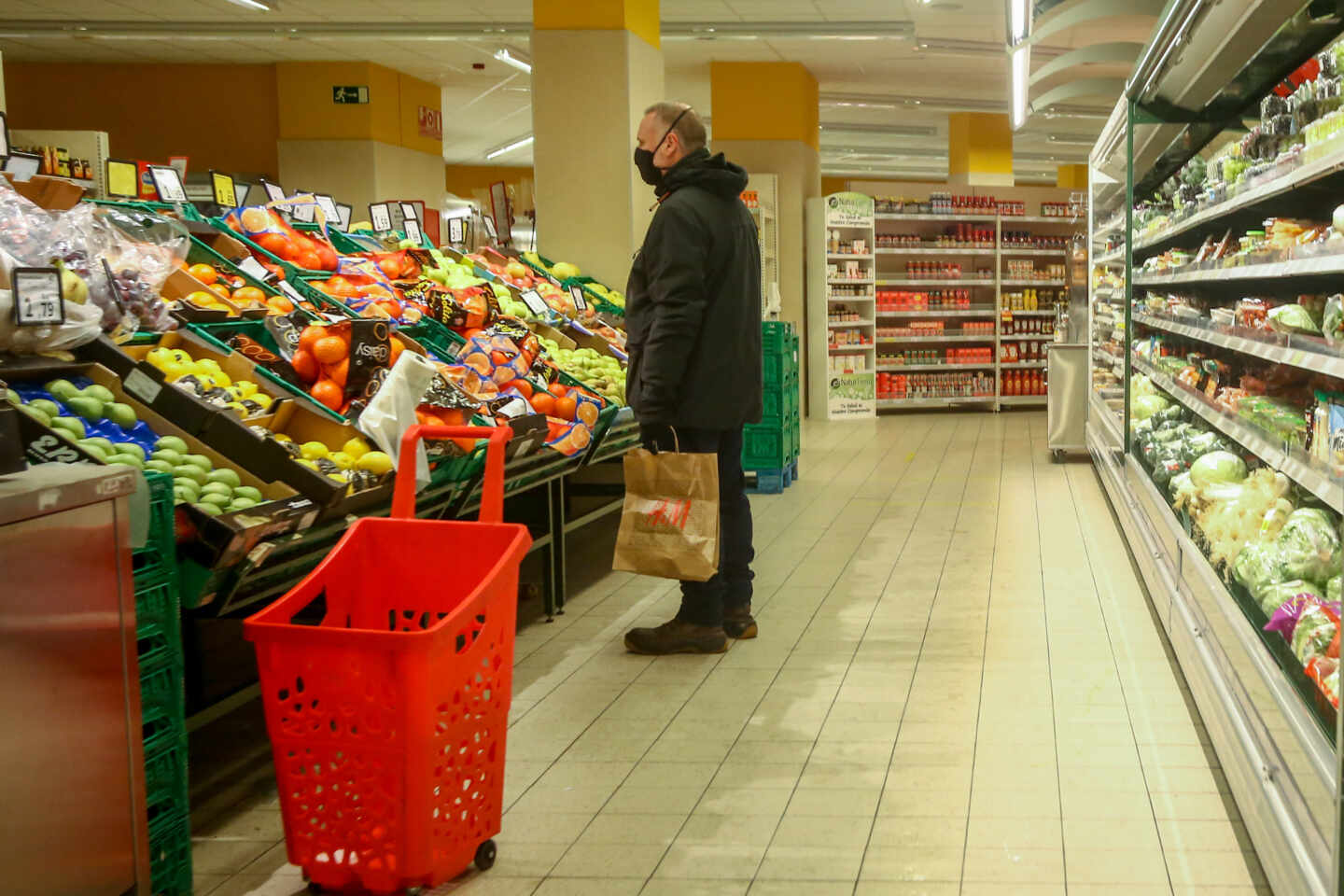 Un hombre en la sección de frutería de un supermercado