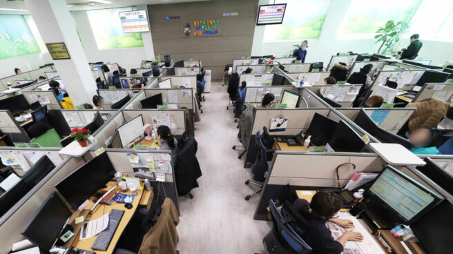 Trabajadores de un call center reciben las llamadas de clientes en una jornada laboral