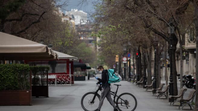 Un trabajador de Deliveroo en bicicleta por una calle de Barcelona.