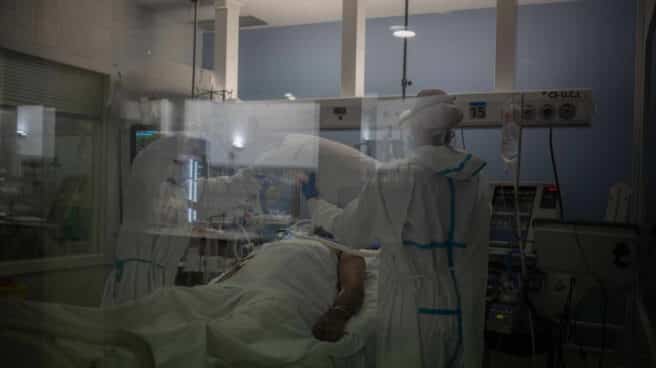 Trabajadores sanitarios atienden a un paciente en la UCI del Hospital del Mar, en Barcelona.