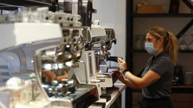 Una camarera sirviendo café en un bar.