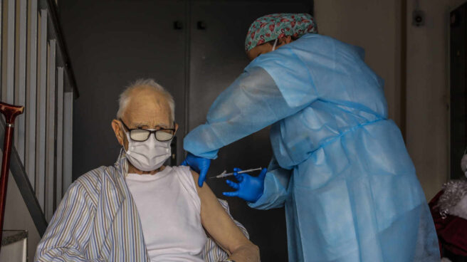 Un anciano es vacunado contra el coronavirus por una sanitaria en Valencia.