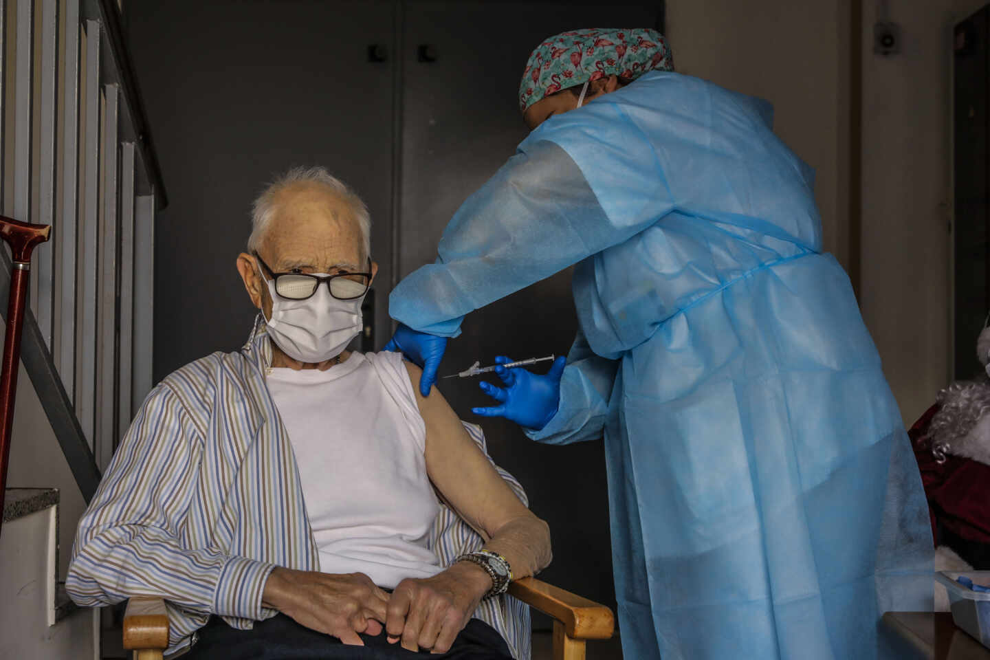 Un anciano es vacunado contra el coronavirus por una sanitaria en Valencia.