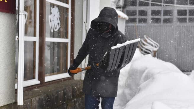 Un hombre aparta la nieve con una pala en el Pirineo aragonés, en Huesca.