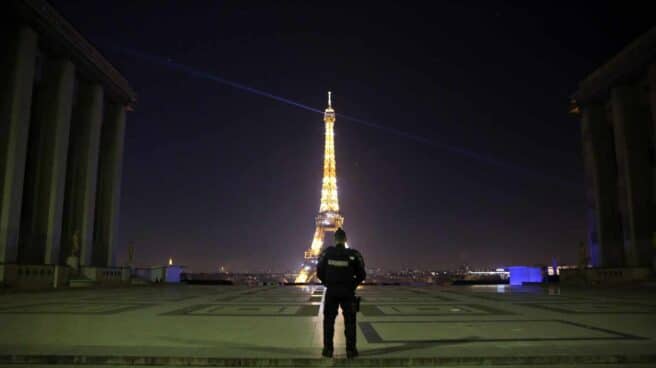 Un policía, ante la Torre Eiffel en París.