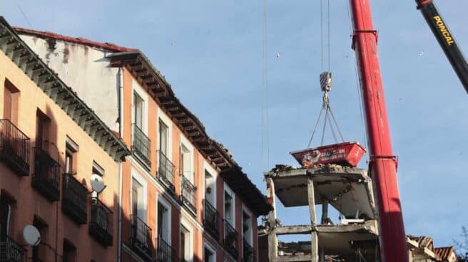Un grúa durante el desmontaje del edificio siniestrado en el número 98 de la calle Toledo, en Madrid
