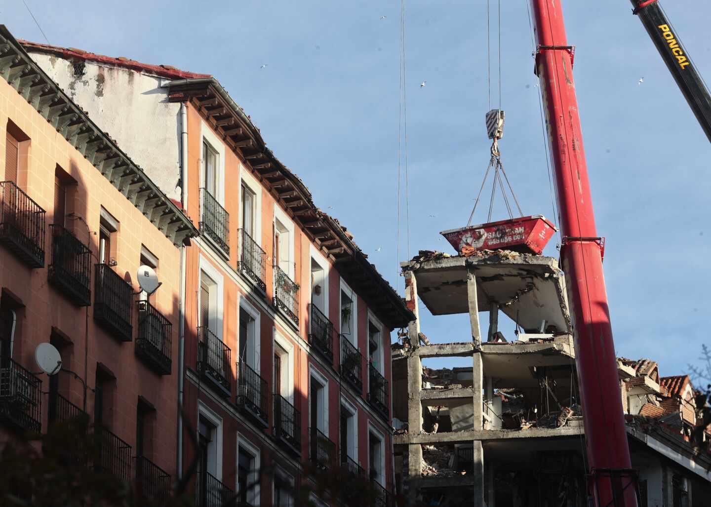 Un grúa durante el desmontaje del edificio siniestrado en el número 98 de la calle Toledo, en Madrid