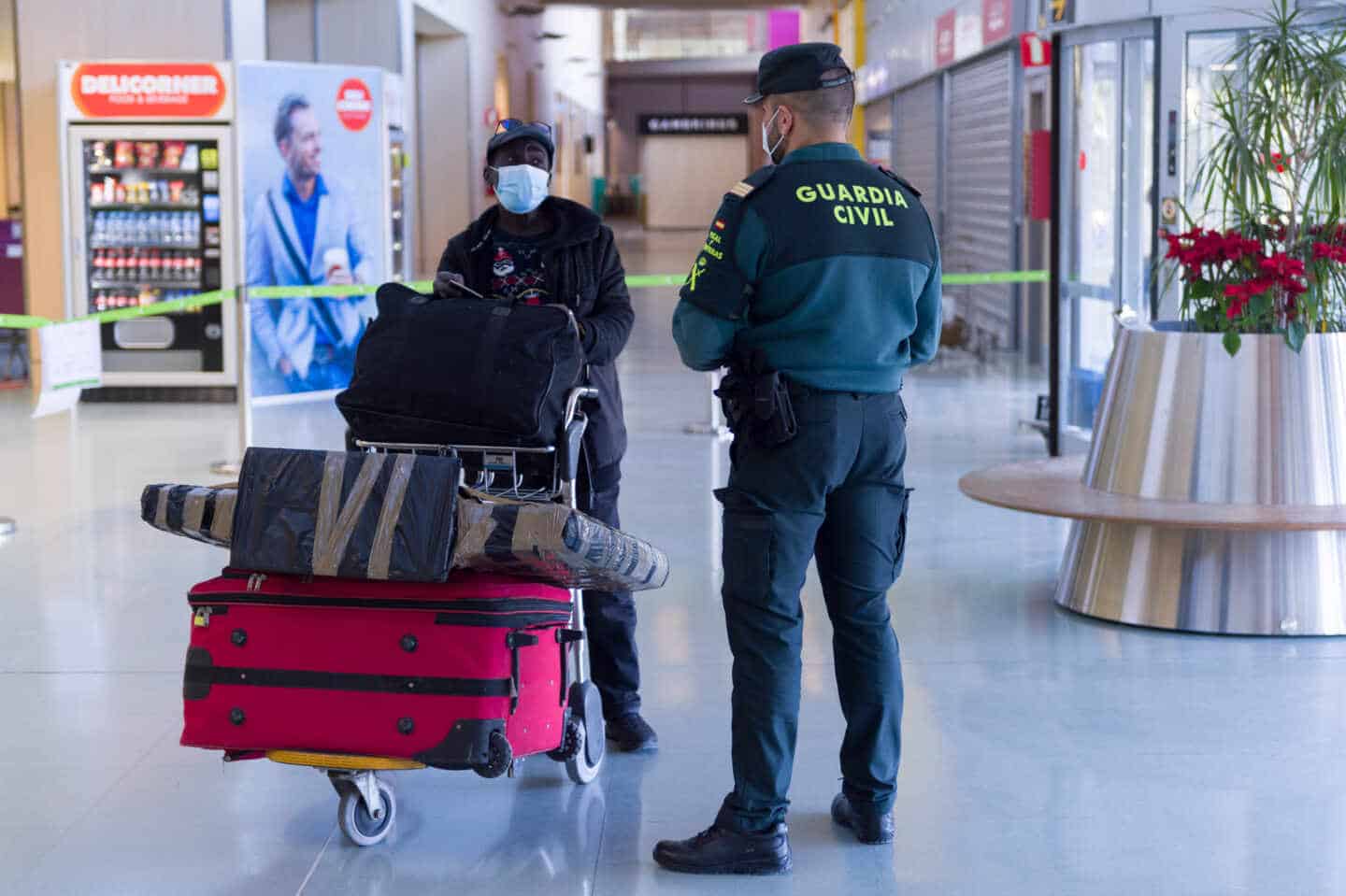 Agentes de la Guardia Civil y empleados de seguridad vigilan a los pasajeros en el interior del Aeropuerto de Ibiza.