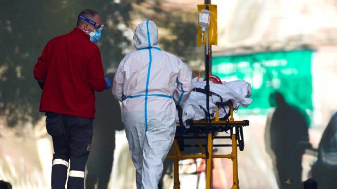 Dos profesionales sanitarios trasladan a un paciente en el hospital de Bellvitge, en Barcelona.