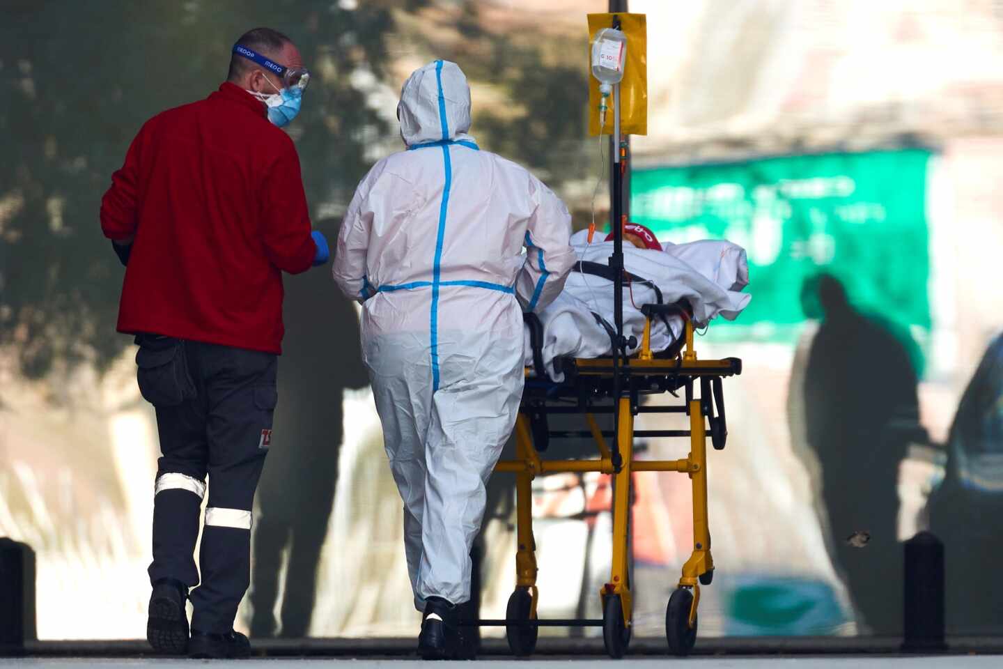 Dos profesionales sanitarios trasladan a un paciente en el hospital de Bellvitge, en Barcelona.