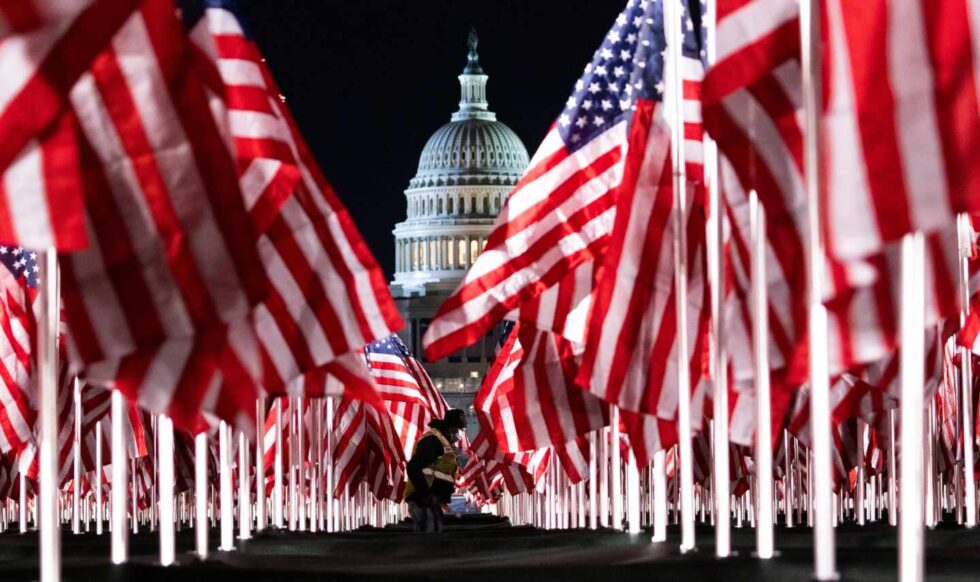 Una persona coloca algunas de las 200.000 banderas de Estados Unidos instaladas frente al Capitolio.