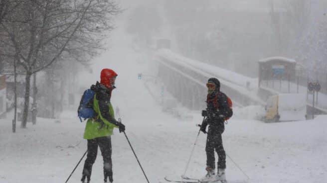 Viandantes esquían por una calle cubierta de nieve en Madrid.