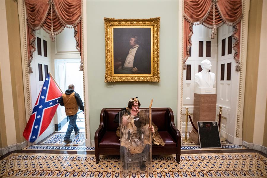 Dos manifestantes, en el interior del Capitolio, uno de ellos con un escudo robado a la Policía.