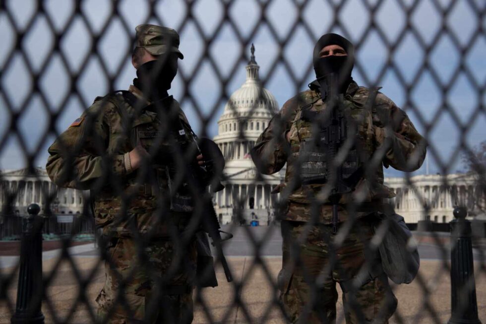 Miembros de la Guardia Nacional vigilan tras una valla en el Ala Este del Capitolio de los Estados Unidos.