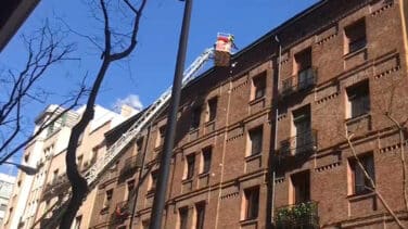 Los bomberos retiran nieve y hielo de las cornisas de la calle Zurbano