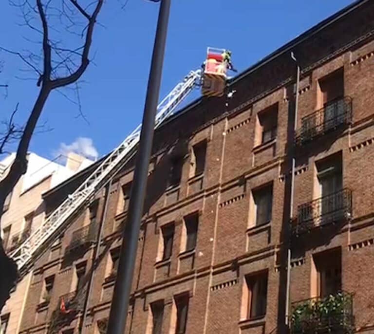 Los bomberos retiran nieve y hielo de las cornisas de la calle Zurbano