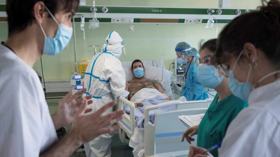 Un paciente de Covid en la UCI mientras un grupo de sanitarios debaten en su presencia.