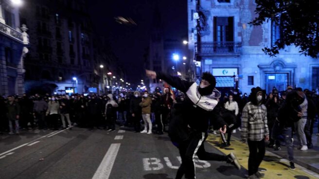 Manifestantes lanzan objetos esta noche frente a la comisaría de Vía Layetana, en el centro de Barcelona, en una nueva manifestación por la libertad de Pablo Hasel, después de cinco días consecutivos de protestas que han finalizado con enfrentamientos con los Mossos d'Esquadra y daños a bienes públicos y privado.