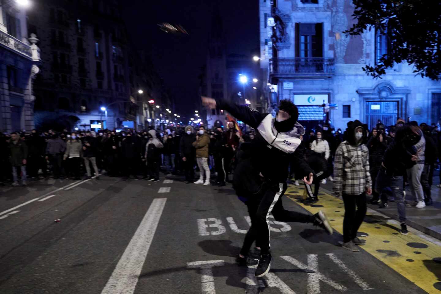 Manifestantes lanzan objetos esta noche frente a la comisaría de Vía Layetana, en el centro de Barcelona, en una nueva manifestación por la libertad de Pablo Hasel, después de cinco días consecutivos de protestas que han finalizado con enfrentamientos con los Mossos d'Esquadra y daños a bienes públicos y privado.