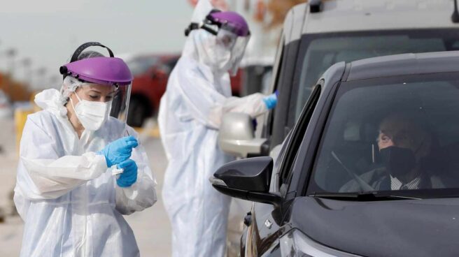 Dos sanitarios realizan PCR a las puertas del hospital de campaña de La Fe, en la Comunidad Valenciana.