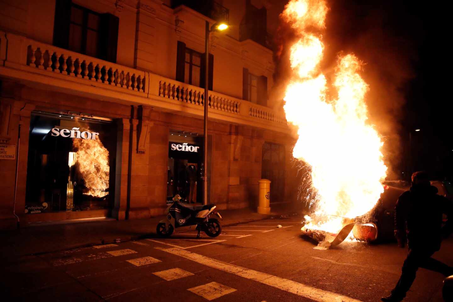 Varias personas queman contenedores durante una concentración en apoyo a Pablo Hasél, el rapero condenado a 9 meses de prisión por enaltecimiento del terrorismo e injurias a la corona, este martes en Barcelona.
