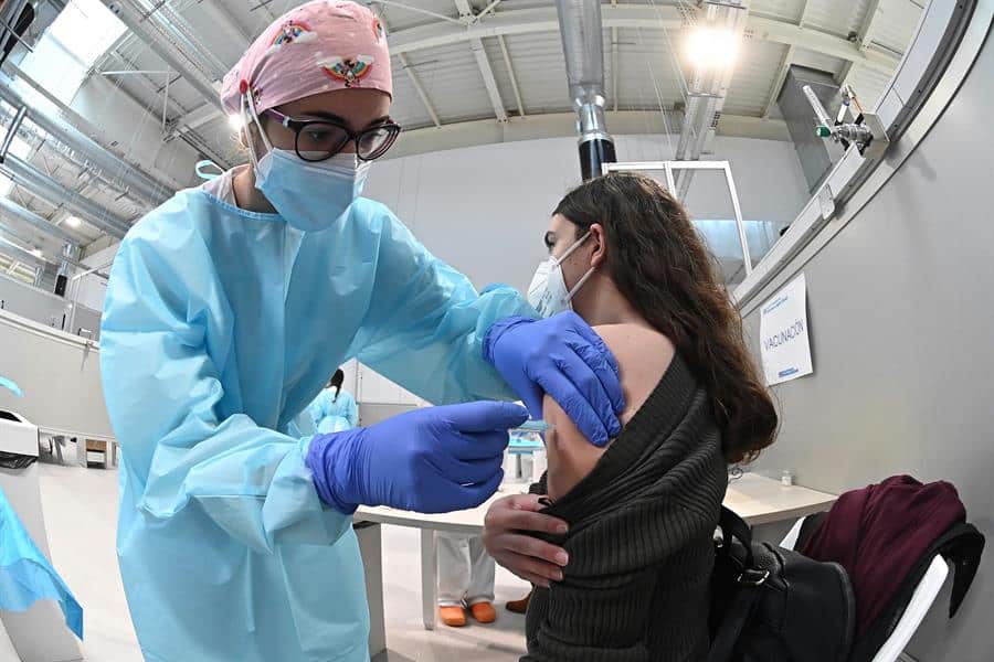 Una sanitaria pone la vacuna contra la covid-19 a una mujer durante el inicio del proceso de vacunación puesto en marcha en el pabellón 3 del hospital Enfermera Isabel Zendal