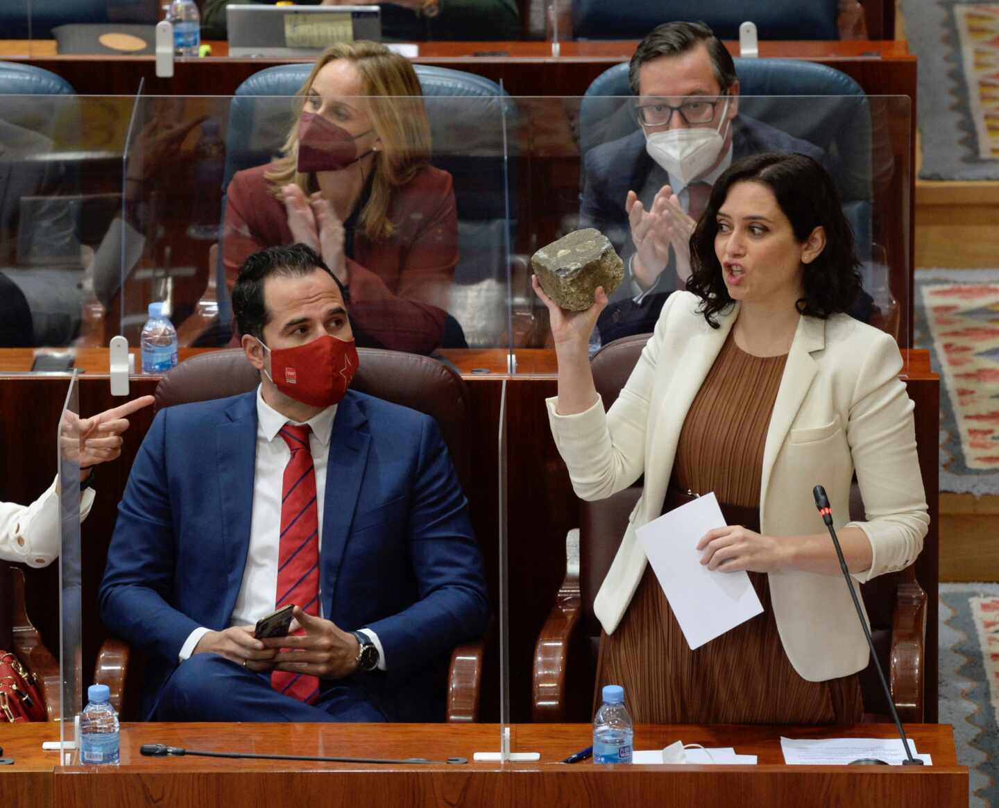 Isabel Díaz Ayuso enseña un adoquín en la Asamblea de Madrid.