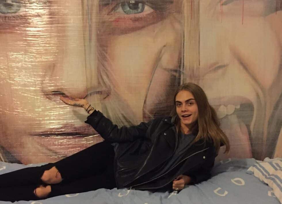 Cara Delevingne posando con su cuadro de René