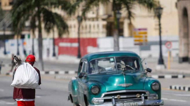 Un automóvil pasa por una calle habanera