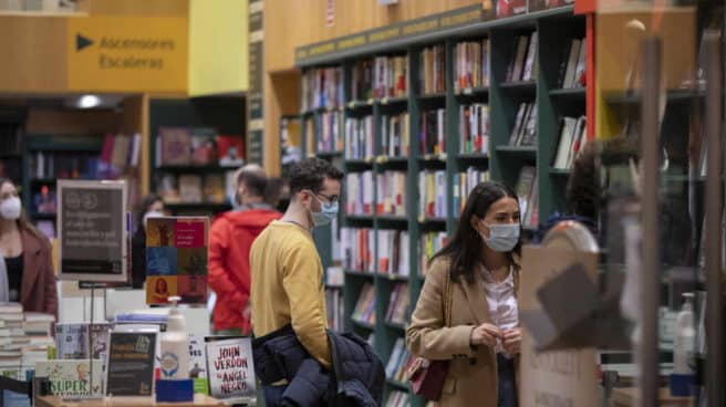 Personas consultan las estanterías de una librería