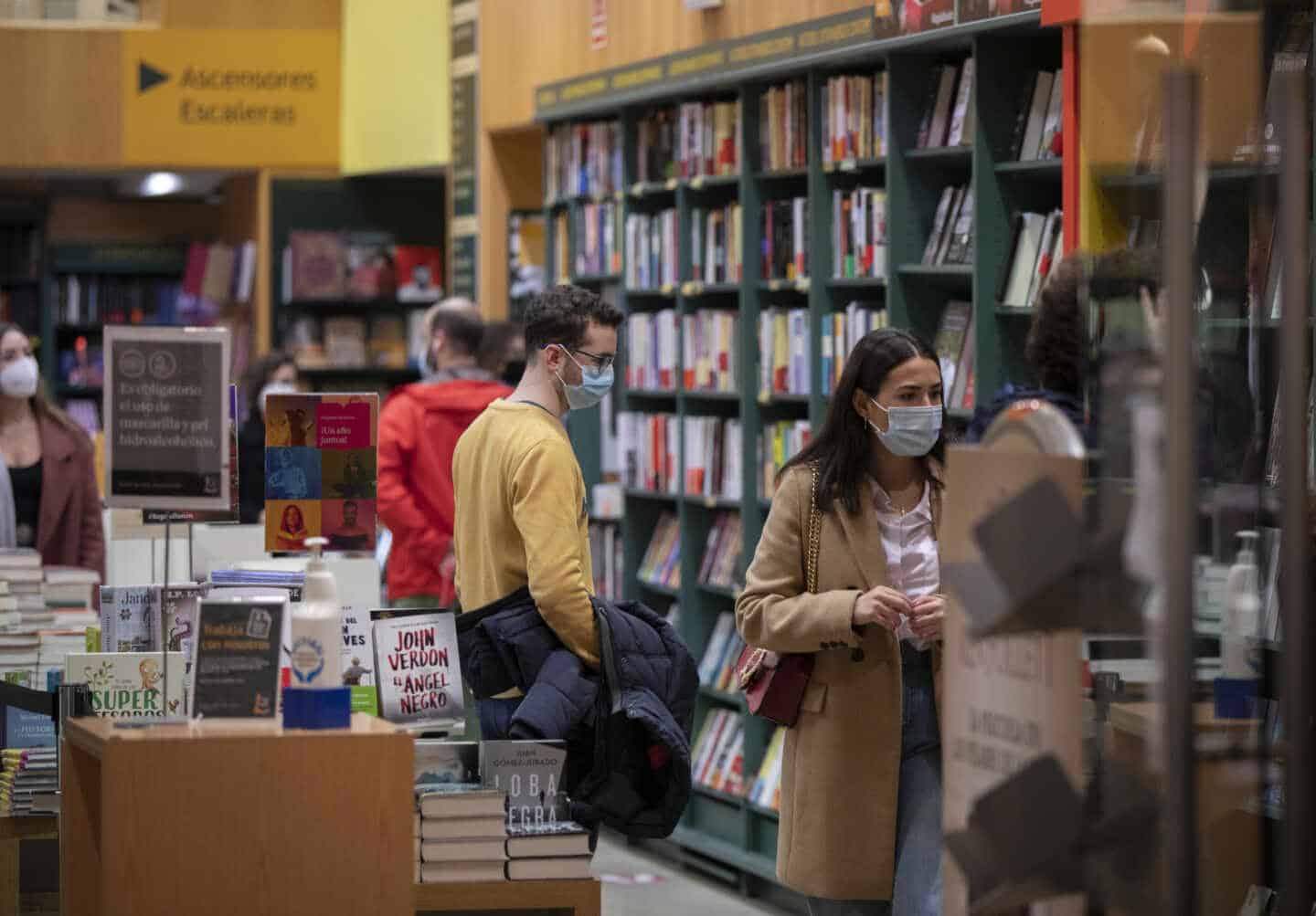 Personas consultan las estanterías de una librería