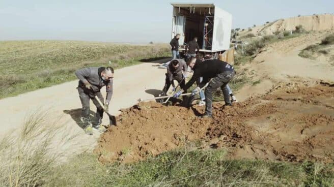 Trabajadores de producción con material de excavación en sus manos en un terreno