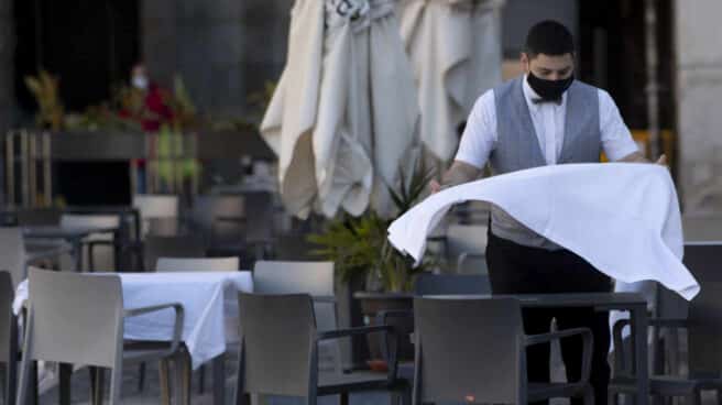 Un camarero prepara la mesa de una terraza de un establecimiento ubicado en la Plaza Mayor